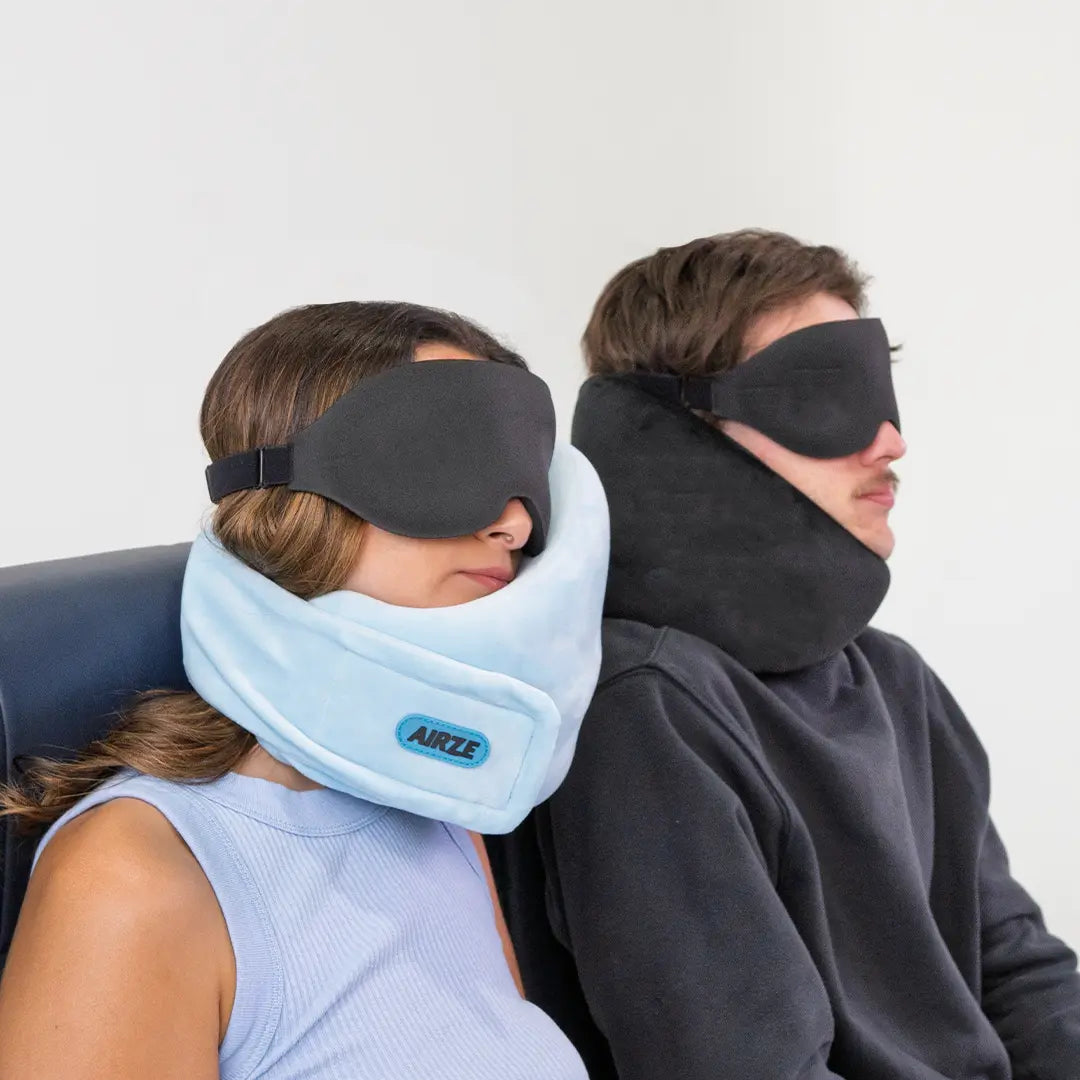 Two travelers using the Airze Eze Sleep Bundle, featuring a supportive travel pillow and blackout sleeping mask for ultimate travel comfort.