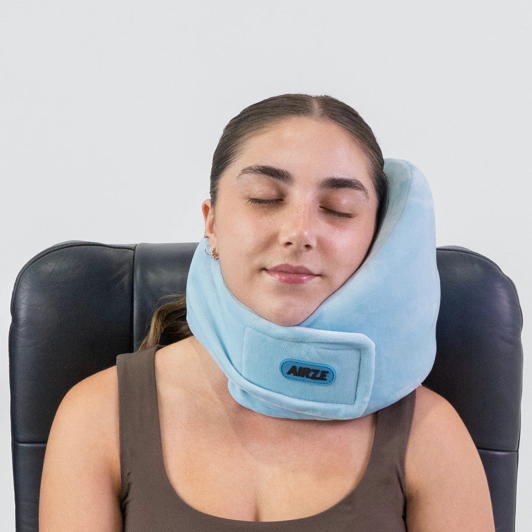 Traveler comfortably resting with the Airze travel pillow in blue, showcasing its ergonomic neck support and plush fabric for superior travel comfort.