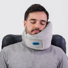 Traveler comfortably resting with the Airze travel pillow in grey, showcasing its ergonomic neck support and plush fabric for superior travel comfort.